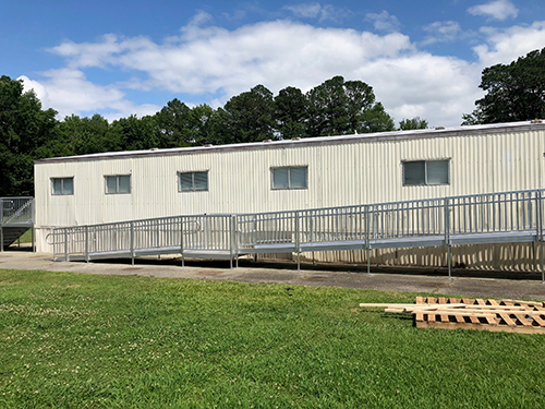 An aluminum commercial ramp installed on a modular building.