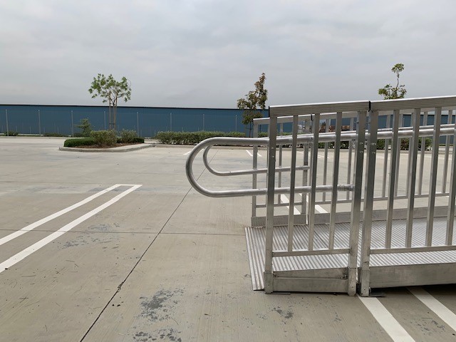 The end of an aluminum commercial ramp in a parking lot.