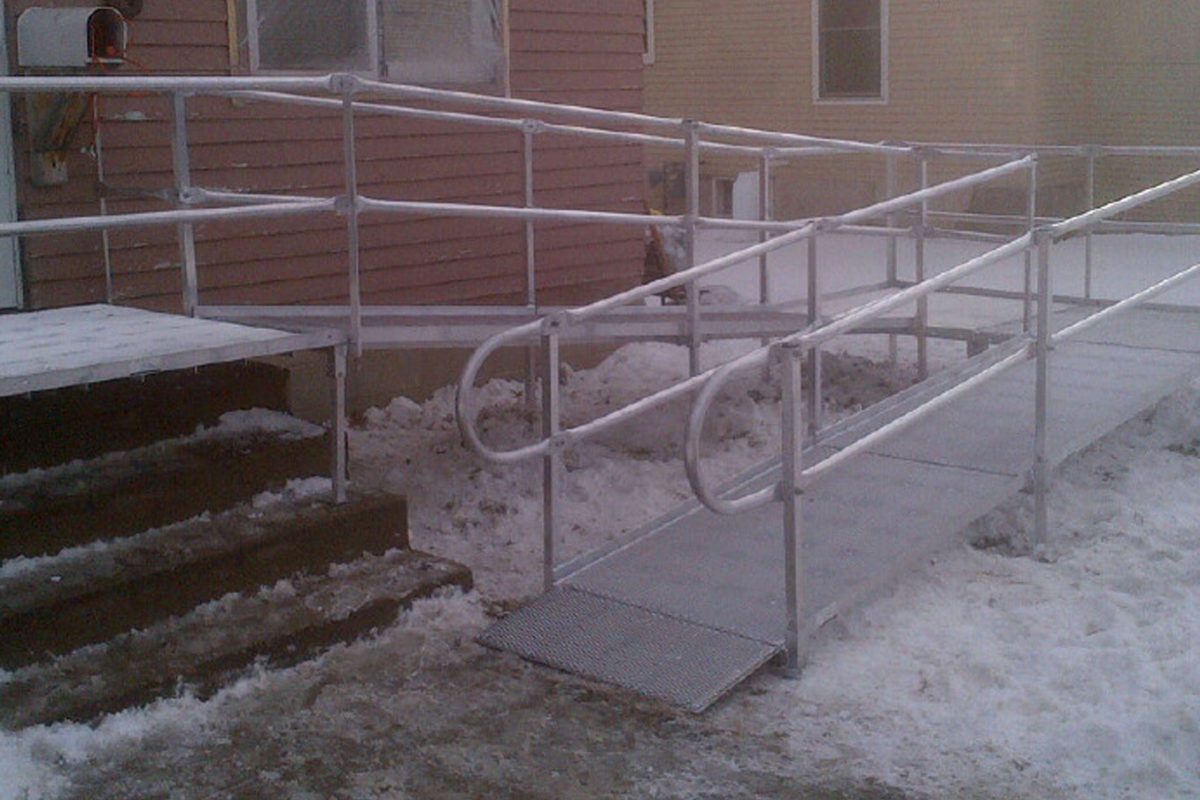 An aluminum mesh ramp after a snowfall. While there is snow on the ground, there isn't any visible snowfall on the ramp surface.
