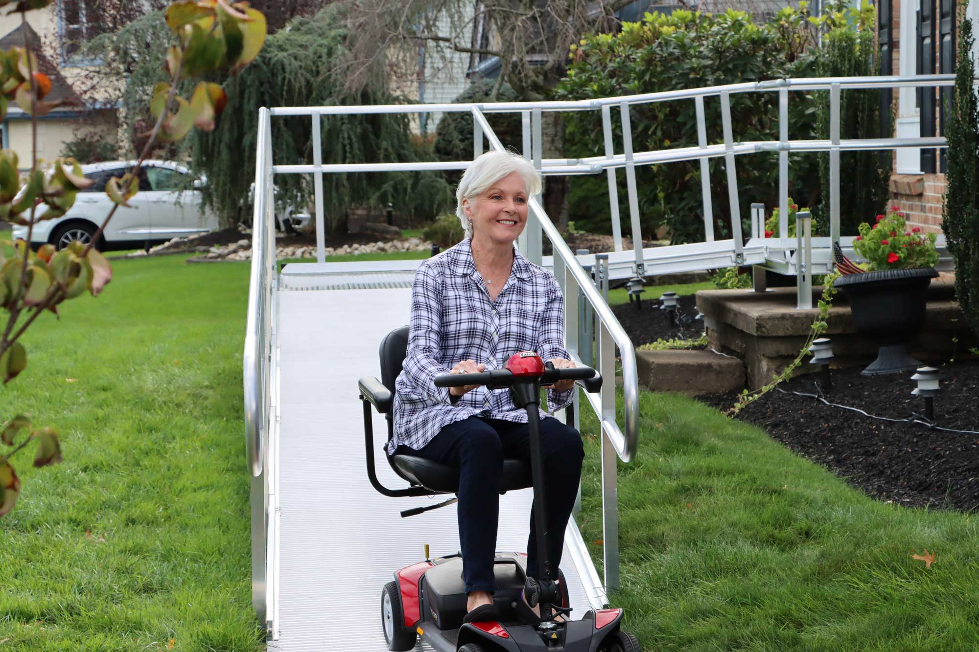 Woman using ramp with scooter.